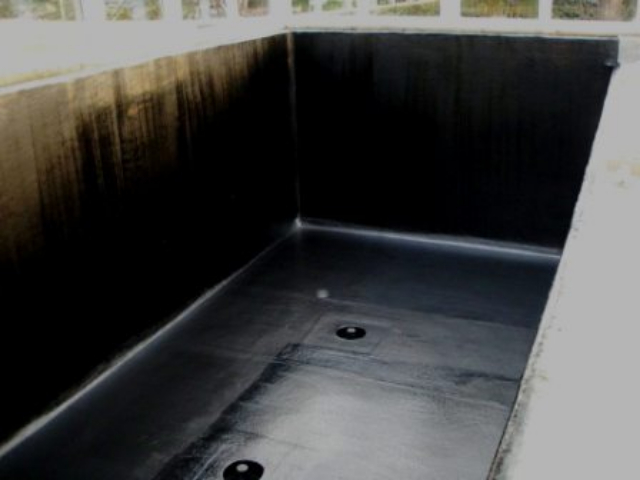 Fibreglass pond lining with black topcoat curing.